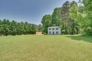 a large yard with a white house in the woods at Seneca Vacation Rental Less Than 1 to Lake Keowee Access! in Seneca