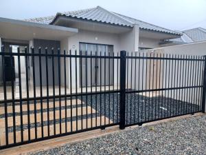 a black fence in front of a house at Casa aconchegante praia - Próximo Beto Carrero Word - 14 Km distância in Itajubá