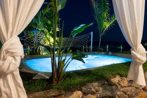 a swimming pool in a yard at night at Villa Zagara Garden Spectacular Sea View in Taormina in Taormina