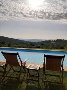 twee stoelen en een tafel naast een zwembad bij Douro Villa with Private Pool in Armamar