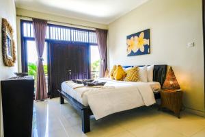 a bedroom with a bed and a large window at Villa LOGAN - KUTA - 5 Bedroom - 3 Bathroom Villa - Great Location in Kuta