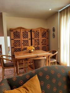 ein Esszimmer mit einem Holztisch und einem Sofa in der Unterkunft Treasure Roses Private Pool Villa in Armamar