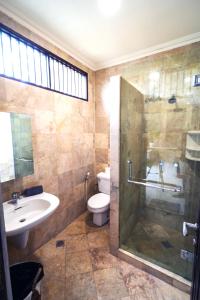 a bathroom with a shower and a sink and a toilet at Villa LOGAN - KUTA - 5 Bedroom - 3 Bathroom Villa - Great Location in Kuta +13 photos
