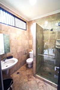 a bathroom with a shower and a sink and a toilet at Villa LOGAN - KUTA - 5 Bedroom - 3 Bathroom Villa - Great Location in Kuta