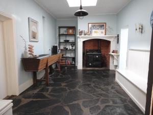 a living room with a table and a fireplace at Bungala House in Yankalilla