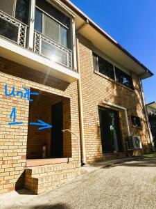 a brick building with two blue arrows on it at Cosy holiday entire unit 1 in Caloundra West