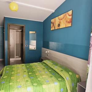 1 dormitorio con cama y pared azul en B&B Villa Maria, en Giardini Naxos