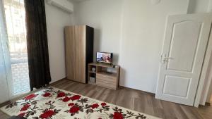 a room with a bed and a tv and a door at Apartment ADELINA in Tsarevo