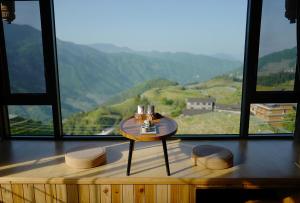 Una mesa en una habitación con vistas a la montaña en Longji One Art Hotel en Longsheng