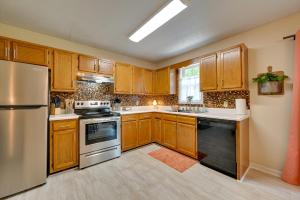 a kitchen with wooden cabinets and stainless steel appliances at Quiet Somerset Retreat - Near Lake Cumberland in Somerset +17 photos