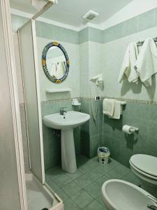 ジャルディーニ・ナクソスにあるB&B Villa Mariaのバスルーム(洗面台、トイレ、鏡付)