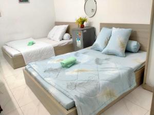 2 Einzelbetten in einem Zimmer mit Spiegel in der Unterkunft Happy Sunshine 1 in Ho-Chi-Minh-Stadt