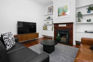 a living room with a couch and a fireplace at Ballantyne Abode in Thebarton