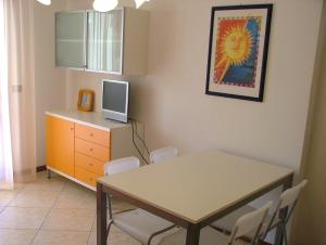 a dining room with a table and a tv on a cabinet at San Pietro D'Orio Apartment in Grado