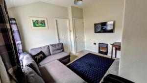 a living room with a couch and a flat screen tv at Converted Railway Cottage in Swindon