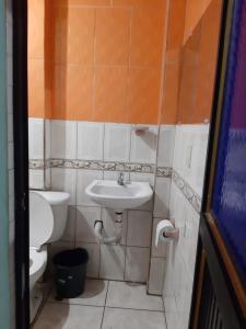 y baño con lavabo y aseo. en Residencial RM en Puerto Francisco de Orellana