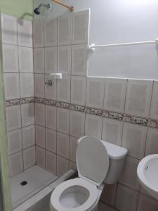 a bathroom with a toilet and a shower and a sink at Residencial RM in Puerto Francisco de Orellana