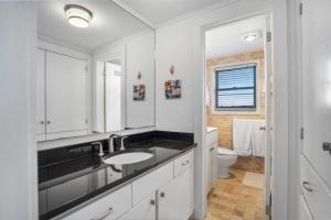 Baño blanco con lavabo y aseo en Driftwood Resort on the Ocean, en Montauk