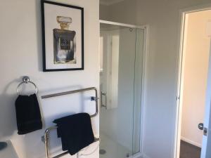 a bathroom with a shower and a towel rack at Cute Cottage Close to Town in Hastings