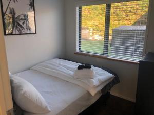 a small bed in a room with a window at Cute Cottage Close to Town in Hastings