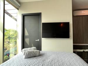 a bedroom with a bed and a flat screen tv at Moderno y Céntrico Aparta-Estudio in Tegucigalpa