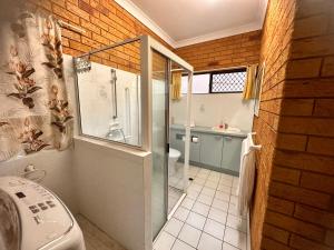 a bathroom with a shower and a toilet and a sink at Cosy holiday entire unit 1 in Caloundra West