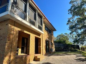 um edifício de tijolos com uma varanda em cima em Cosy holiday entire unit 1 em Caloundra West