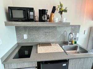a kitchen counter with a microwave and a sink at Moderno y Céntrico Aparta-Estudio in Tegucigalpa