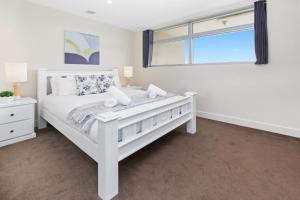 a white bedroom with a white bed and a window at Salt Five Apartment Sorrento - Main Street Location in Sorrento