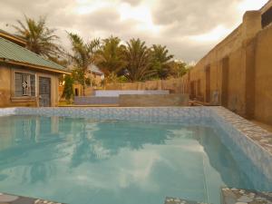 a large swimming pool with blue water in a yard at CRYSTAL HOMES Air BnB in Mumias