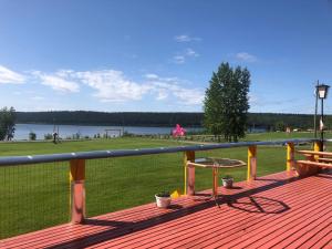 a deck with a picnic table and a view of a park at Cariboo Log Guest House in Lac La Hache