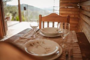 una mesa de madera con un plato y gafas. en Chalé do Vale locação de temporada, en Águas de Lindóia