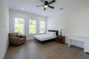 a bedroom with a bed and a chair and windows at Ocean Estate in Fort Pierce