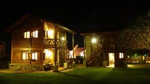 a log cabin at night with its lights on at Rincón de los Troncos in Merlo