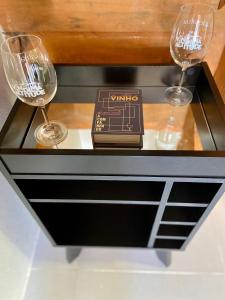 dois copos de vinho e um livro sobre uma mesa em Loft na Serra Catarinense em São Joaquim