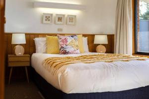 ein Schlafzimmer mit einem großen Bett mit zwei Lampen in der Unterkunft Beach Break - Diamond Island in Bicheno