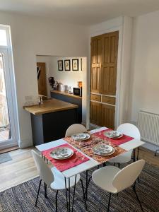 a dining room table with four chairs and a kitchen at Comfortable 2 bedroom home from home with parking in Nottingham