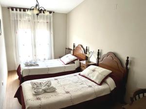 1 dormitorio con 2 camas y ventana en Casa Rural Valito, en Armallones