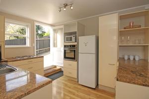 una cucina con frigorifero bianco e lavandino di 2 Bed Apartment in Kingsland - FREE WIFI and parking ad Auckland