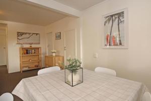 2 Bed Apartment in Kingsland - FREE WIFI and parking في أوكلاند: غرفة طعام مع طاولة مع كراسي بيضاء