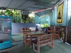 a restaurant with wooden tables and chairs and a bench at Restaurante y cabinas Sudy in Carara