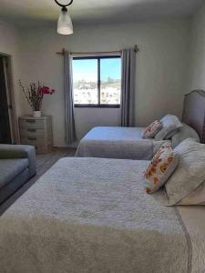 a bedroom with two beds and a window at Casa San Patricio in San Miguel de Allende