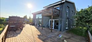 a house with a wooden deck with a building at Stilren svit lägenhet med trädäck och laddstation in Motala