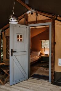 uma porta que leva a um quarto com uma cama em Sioglamping in Siocamping em Siófok
