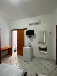 a room with a small refrigerator and a television at Pousada Pedra Furada in Jericoacoara