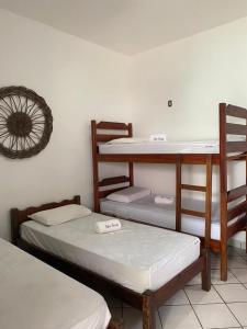 a room with two bunk beds and a clock on the wall at Pousada Pedra Furada in Jericoacoara