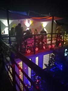 eine Gruppe von Menschen, die nachts in einer Bar sitzen in der Unterkunft Tu Jardín Secreto in La Serena