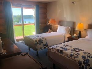 a hotel room with two beds and a large window at Cariboo Log Guest House in Lac La Hache