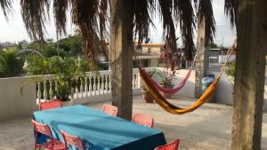 uma mesa e cadeiras e uma rede de descanso num pátio em Pangora, habitación privada de Flor de Lis Beach House em Playas