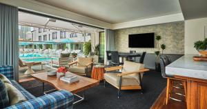 a living room with a tv and a pool at Pendry San Diego in San Diego